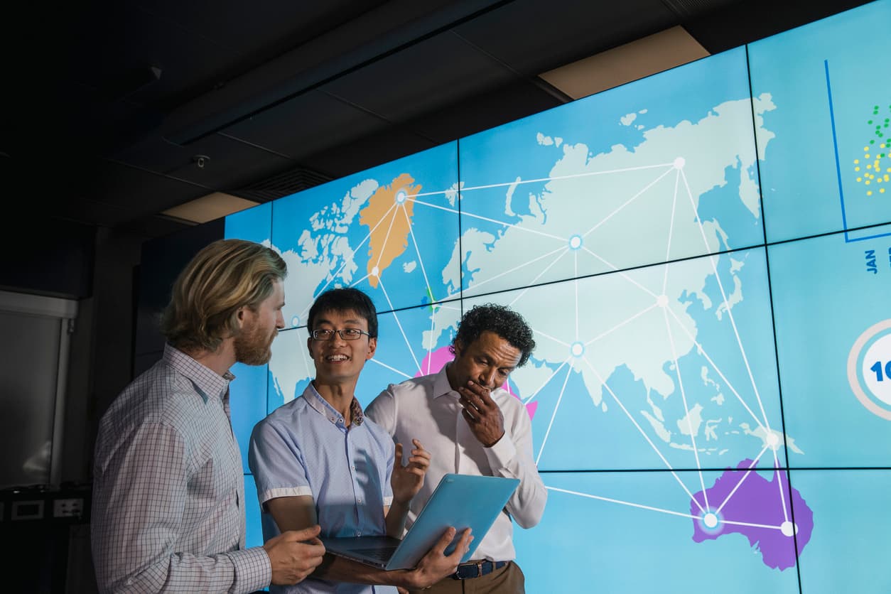 diskutierende Menschen vor einer Weltkarte